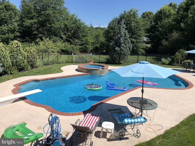 view of pool with a fenced backyard, a pool with connected hot tub, and a patio