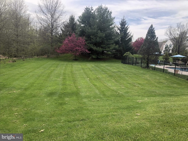 view of yard featuring fence and a fenced in pool