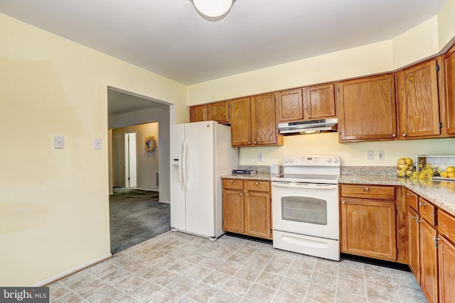 kitchen featuring under cabinet range hood, baseboards, white appliances, and brown cabinets