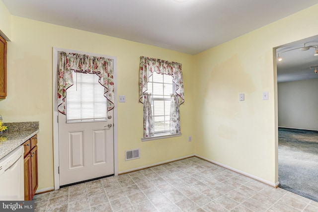 doorway to outside featuring light colored carpet, visible vents, and baseboards