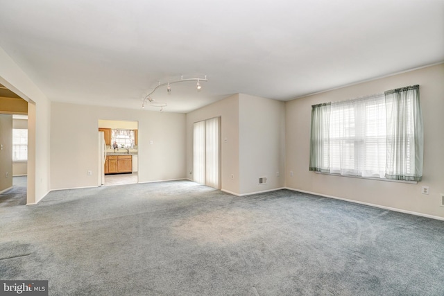 spare room with visible vents, baseboards, and carpet flooring