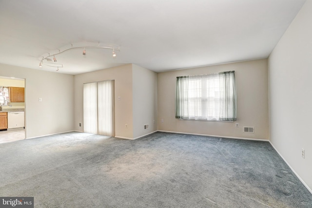 empty room with light colored carpet, visible vents, and baseboards