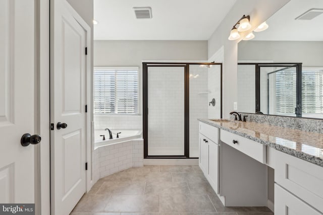 bathroom featuring vanity, a shower stall, a bath, and visible vents