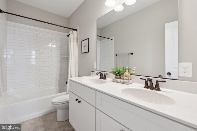 bathroom featuring a sink, shower / bath combo with shower curtain, toilet, and tile patterned flooring