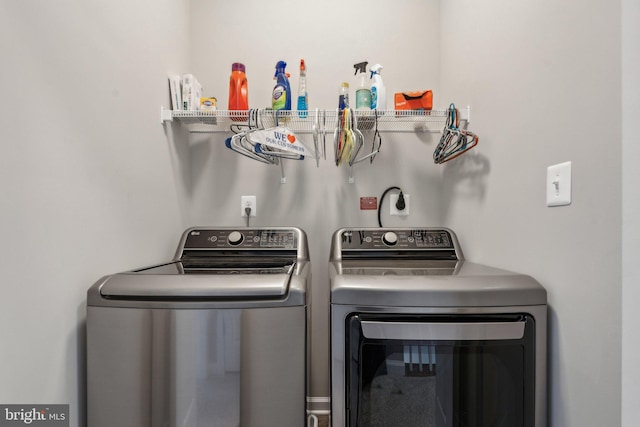 clothes washing area with washer and clothes dryer and laundry area