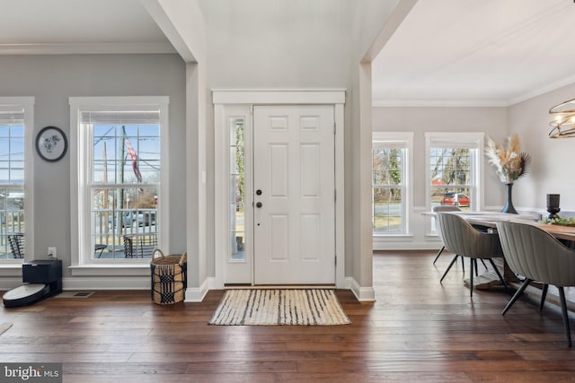 entryway featuring dark wood finished floors, crown molding, and baseboards