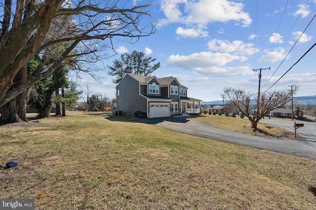 view of front of house with a garage, a front lawn, and driveway