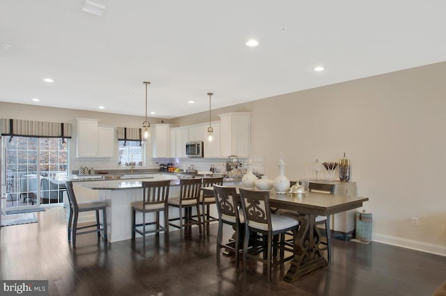 dining room featuring dark wood-style flooring, recessed lighting, and baseboards