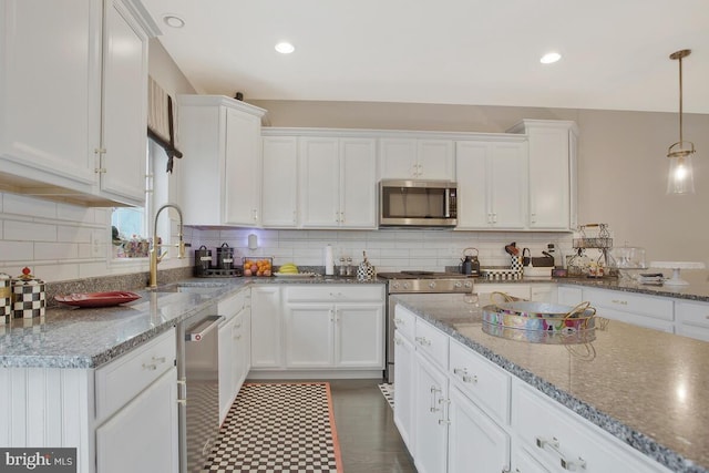 kitchen with stainless steel appliances, white cabinets, and tasteful backsplash