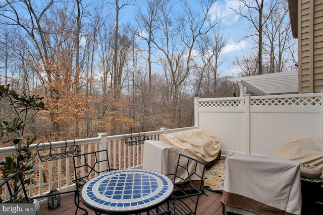 wooden deck with outdoor dining space and fence