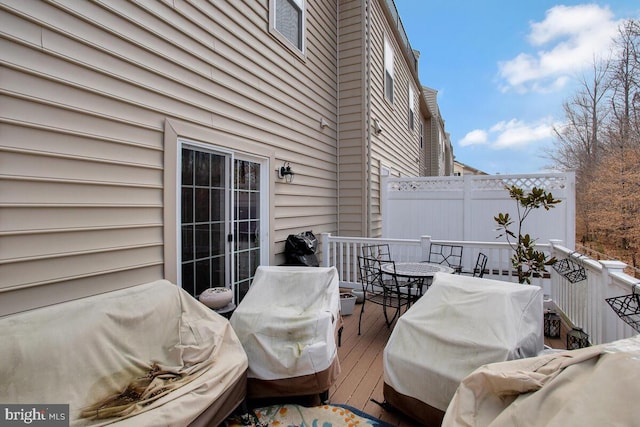 view of patio featuring area for grilling, a wooden deck, and fence