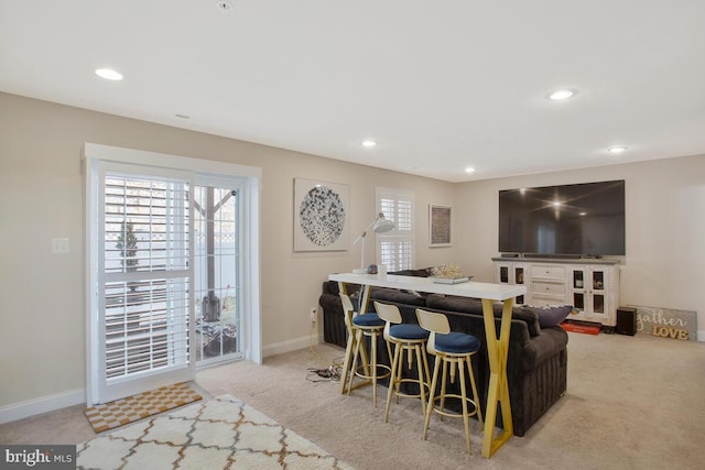 living area featuring light carpet, baseboards, and recessed lighting