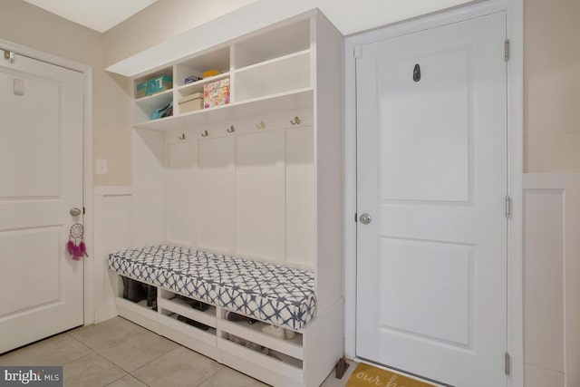 mudroom featuring light tile patterned floors and a wainscoted wall