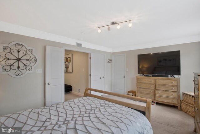 bedroom featuring ornamental molding, carpet flooring, and visible vents