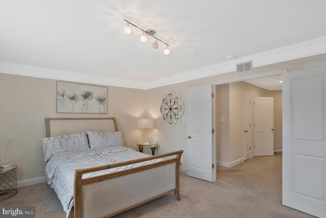 bedroom featuring light carpet, ornamental molding, visible vents, and baseboards