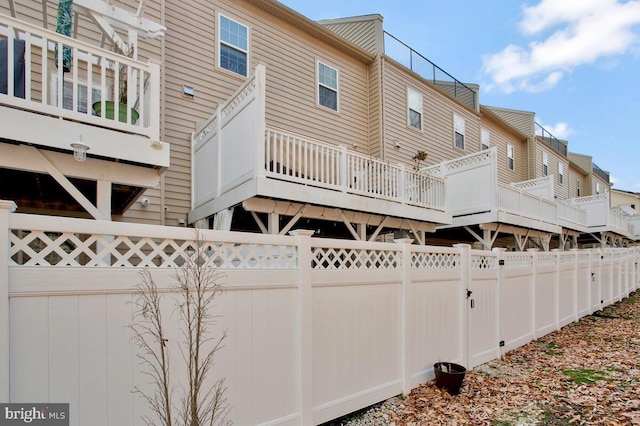 rear view of property with a fenced backyard and a wooden deck