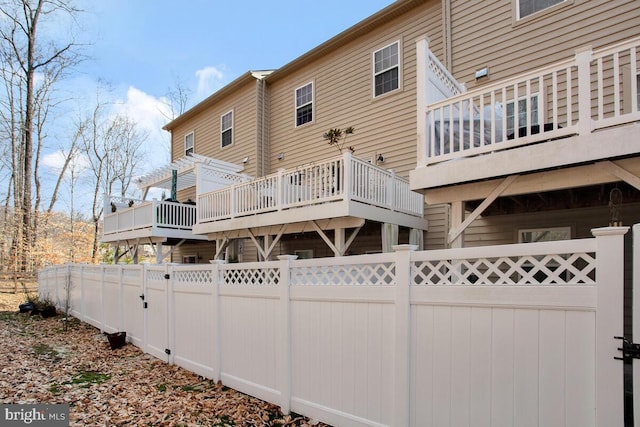 rear view of house with a fenced backyard