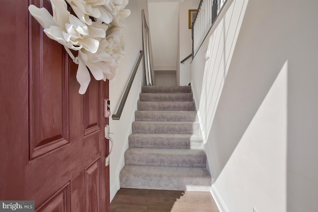 staircase with baseboards and wood finished floors