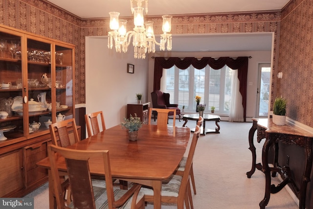 dining area with wallpapered walls, crown molding, a notable chandelier, and light colored carpet