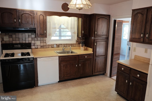 kitchen featuring white dishwasher, under cabinet range hood, a sink, light countertops, and gas range