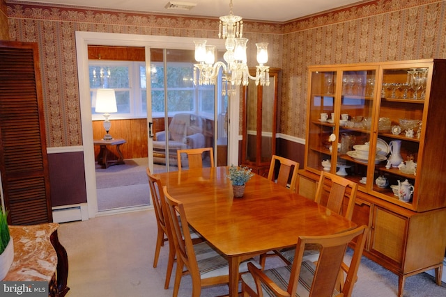 carpeted dining room featuring a baseboard radiator, visible vents, an inviting chandelier, and wallpapered walls