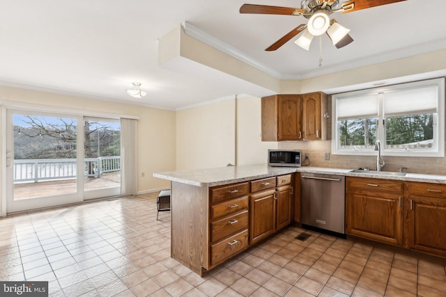 12106 Preston Dr, Lusby, MD 20657 - kitchen with brown cabinetry, a peninsula, tasteful backsplash, a sink, and appliances with stainless steel finishes