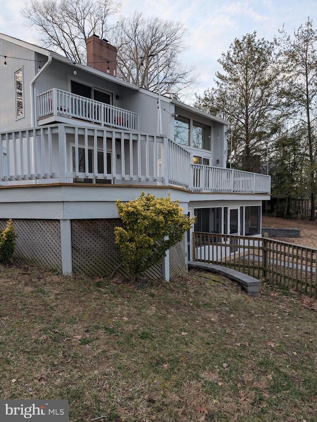 back of property featuring a chimney and a balcony