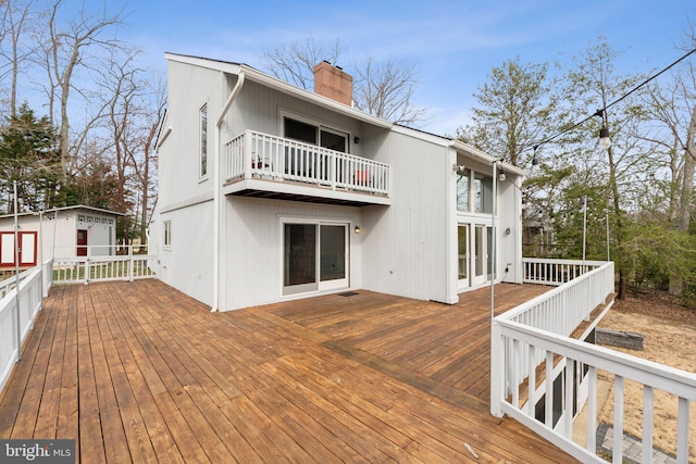 12106 Preston Dr, Lusby, MD 20657 - back of property featuring a deck, an outbuilding, a chimney, and a balcony