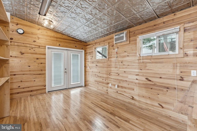 12106 Preston Dr, Lusby, MD 20657 - spare room featuring an ornate ceiling, wooden walls, a wall mounted AC, hardwood / wood-style flooring, and french doors
