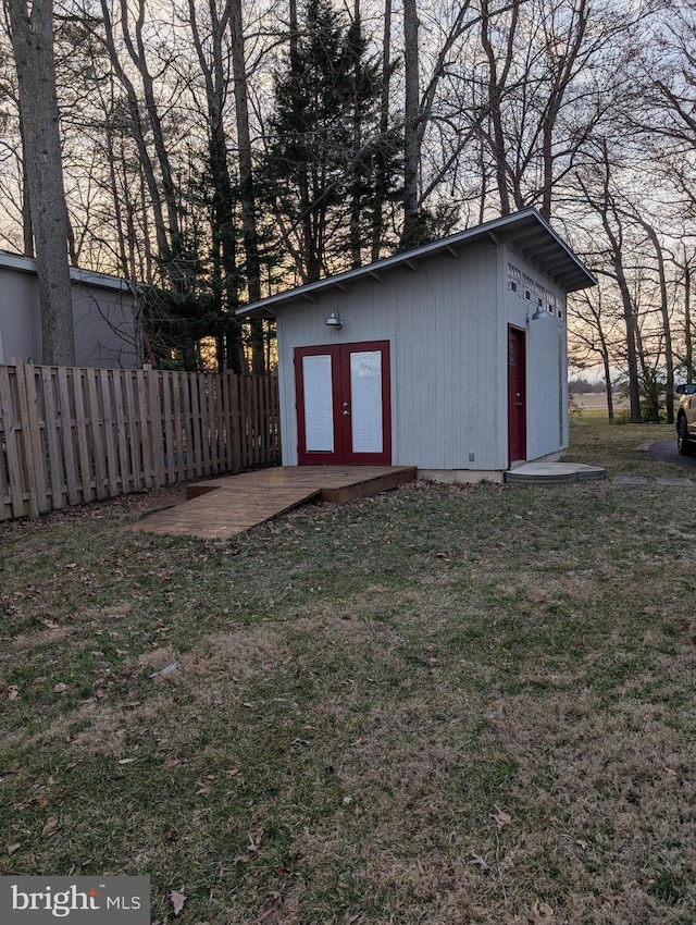 view of outdoor structure featuring an outbuilding and fence