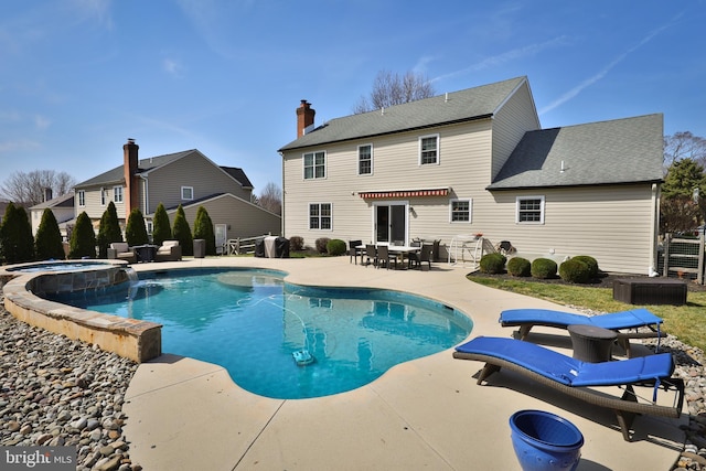 view of swimming pool with outdoor dining space, a grill, a pool with connected hot tub, and a patio