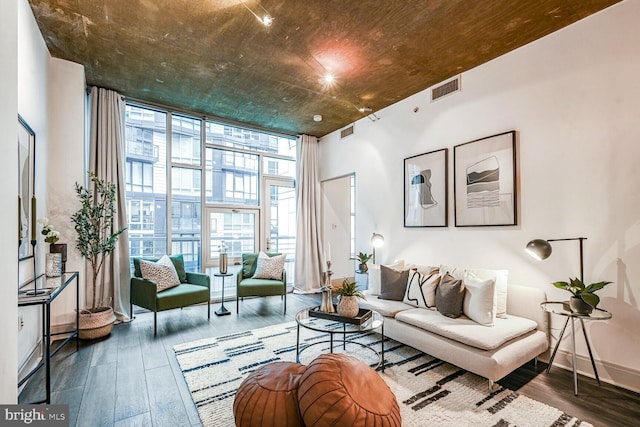 living room with baseboards, expansive windows, visible vents, and wood finished floors