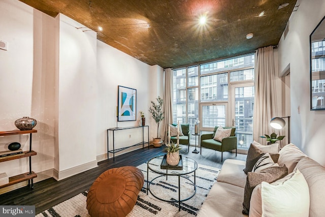 living area with baseboards, wood finished floors, and floor to ceiling windows