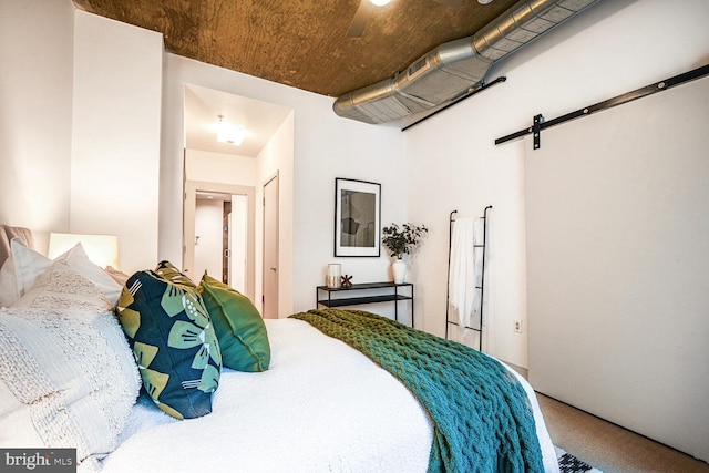 carpeted bedroom featuring a barn door