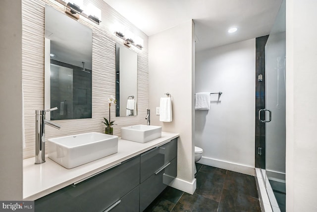 full bathroom with a stall shower, baseboards, and a sink