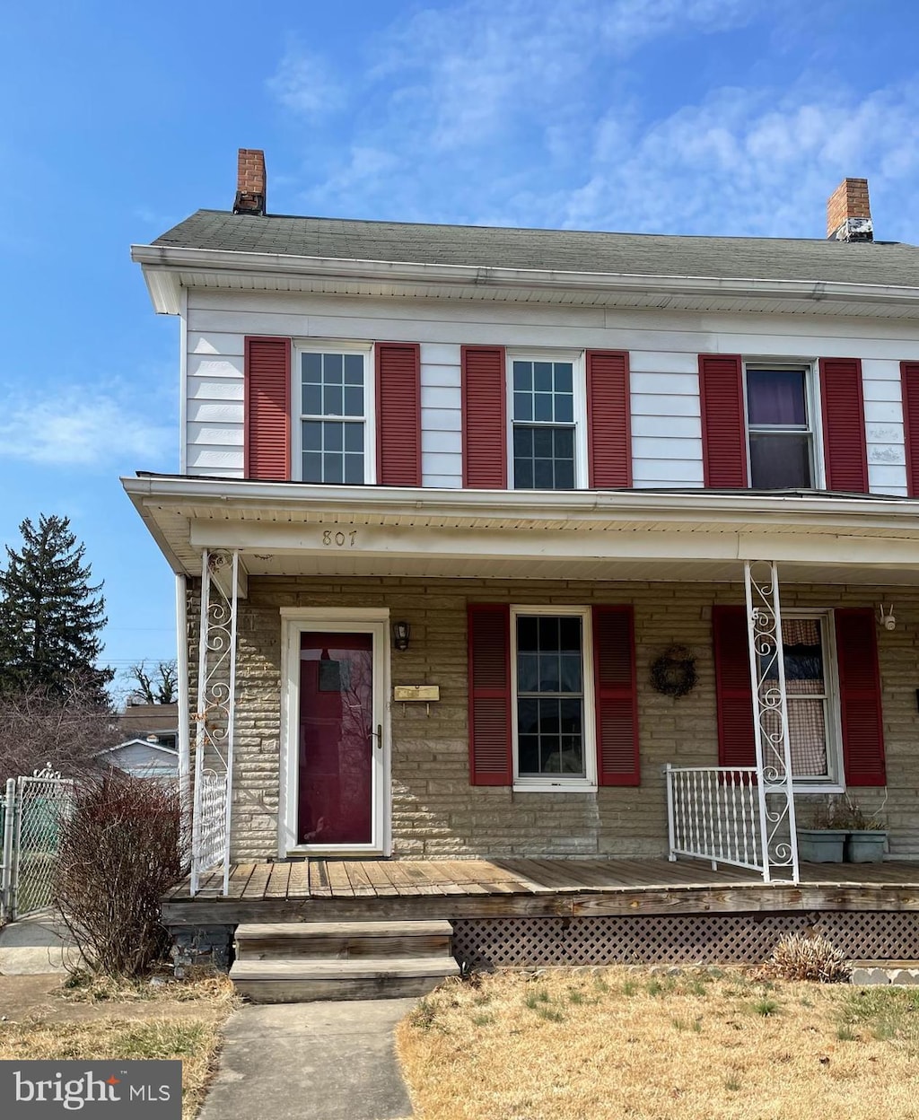 view of front of home featuring covered porch and a chimney