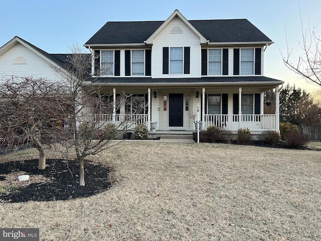 colonial house with a porch and roof with shingles