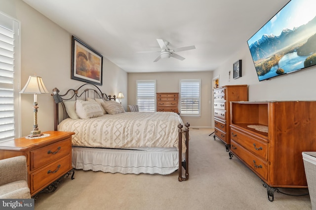 bedroom featuring a ceiling fan, baseboards, and light carpet