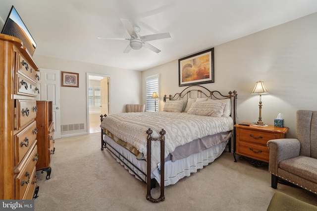 bedroom with a ceiling fan, light colored carpet, and visible vents