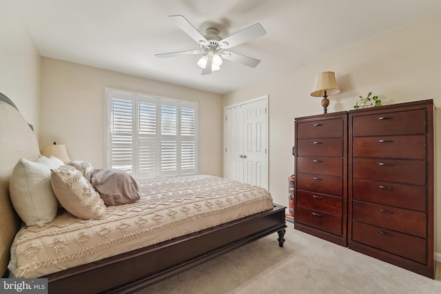 bedroom with a closet, light carpet, and a ceiling fan