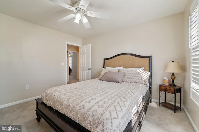 bedroom featuring light colored carpet, baseboards, and ceiling fan