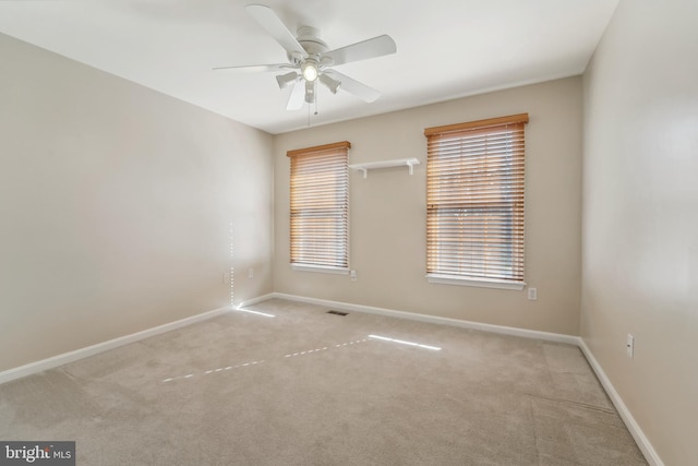 unfurnished room featuring visible vents, baseboards, carpet floors, and a ceiling fan