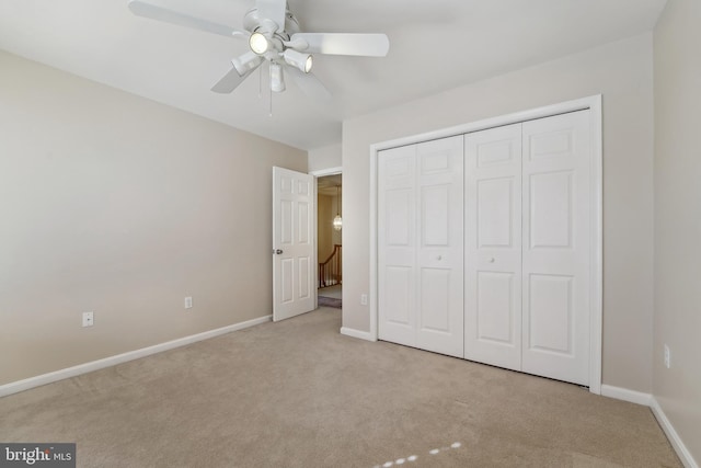 unfurnished bedroom featuring a closet, carpet flooring, a ceiling fan, and baseboards