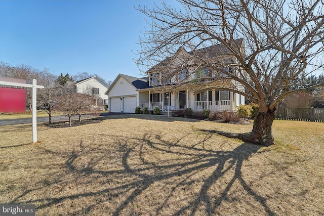 view of front of house featuring a porch, fence, a garage, and a front yard