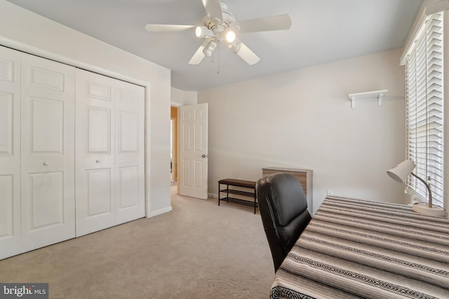 carpeted office with baseboards and a ceiling fan