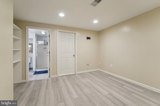 spare room featuring visible vents, light wood-type flooring, and baseboards