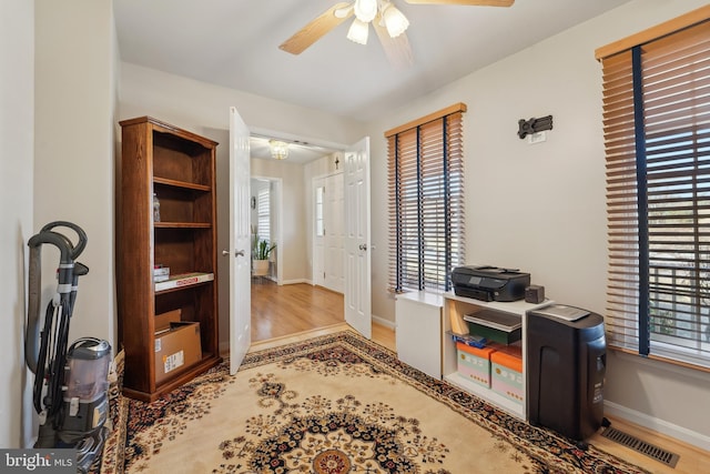 office area with visible vents, baseboards, ceiling fan, and wood finished floors