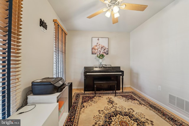 living area with visible vents, baseboards, and ceiling fan