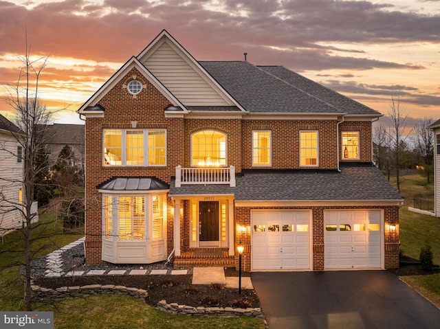 view of front of property with brick siding, an attached garage, a shingled roof, a balcony, and driveway