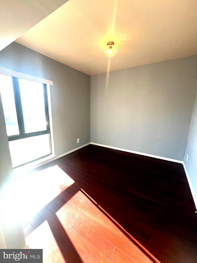 empty room featuring baseboards and wood finished floors